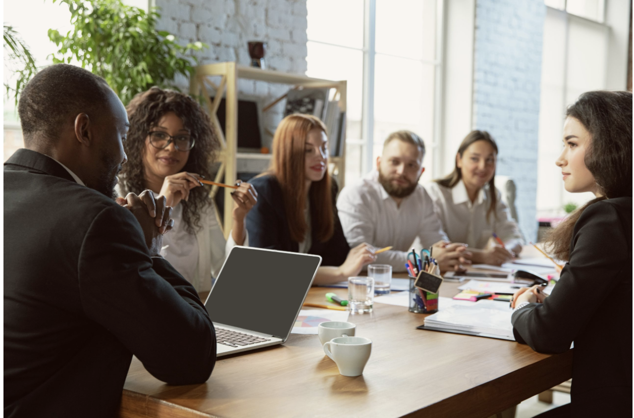 Diverse group of professionals in a coaching session around a conference table in a modern office