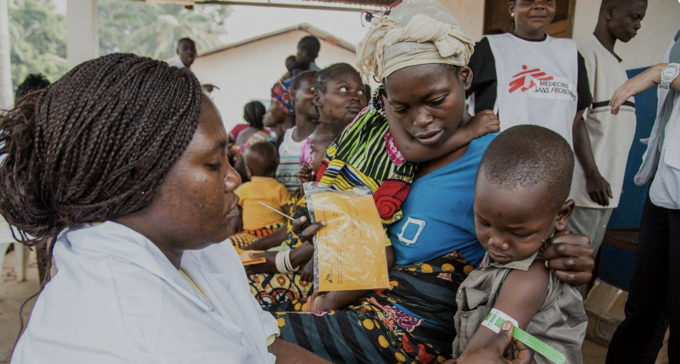 Healthcare worker providing compassionate care to a mother and child, demonstrating the real-world impact of charitable donations